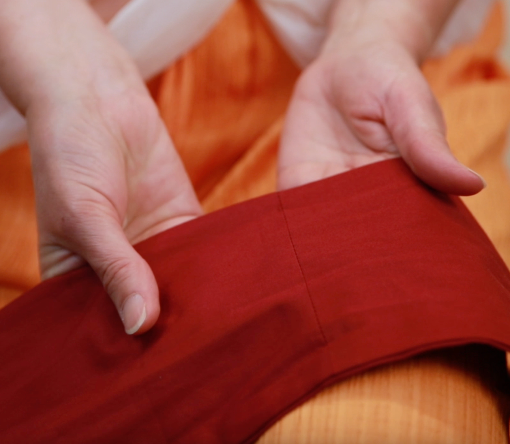 Close-up of a woman's hands holding the red band of the two-piece turban set