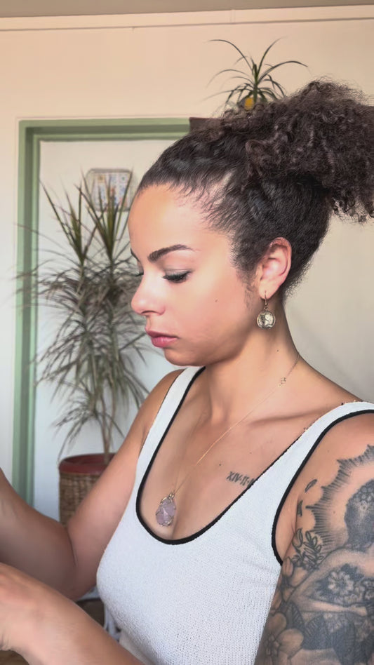 Video of a woman putting on the Aisha Crown, an olive green turban with a geometric print